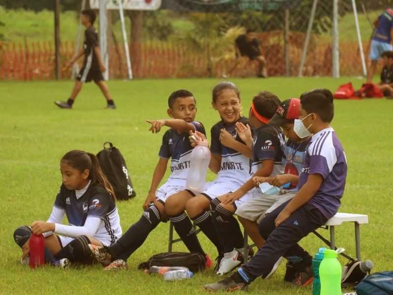 En la banca, Regis ríe con sus compañeros de equipo mixto, mientras Linet descansa sobre el pasto. (Foto: Iván Sánchez)